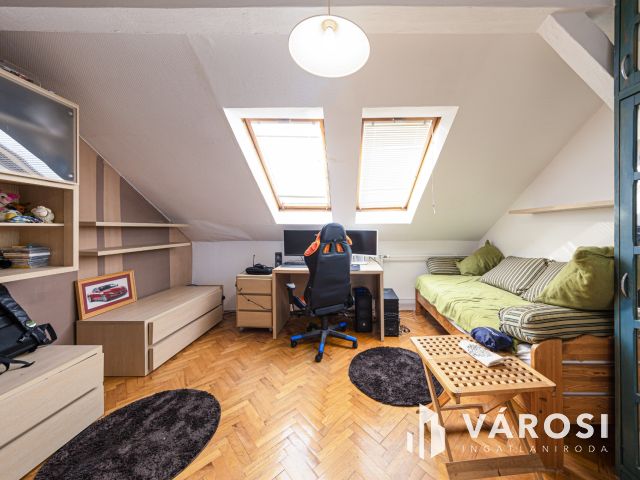 Látszó fagerendás tetőtéri lakás csendes utcában